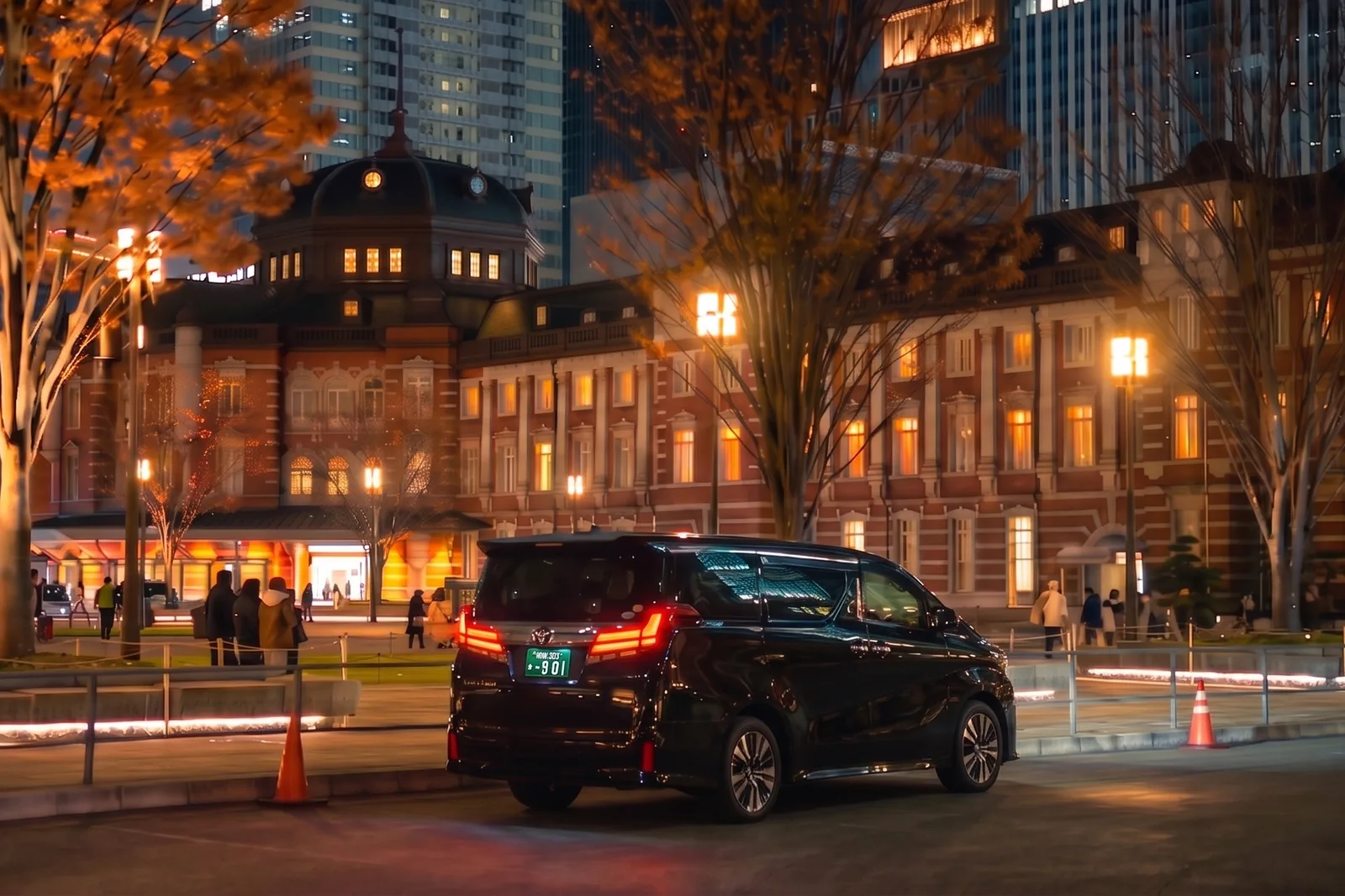 Black private transfer vehicle outside Tokyo Station at night