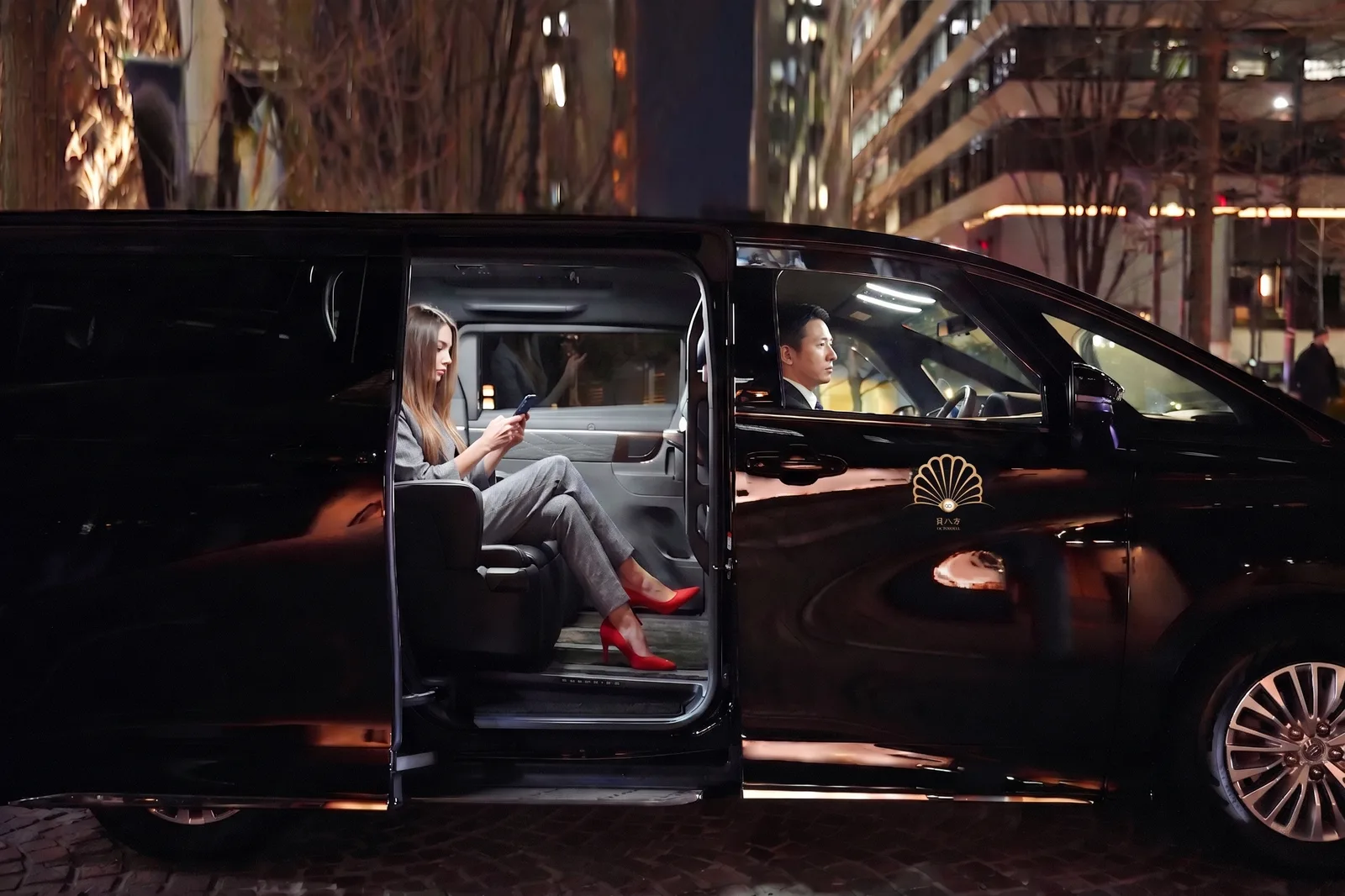 Octoshell Japan chauffeur welcoming a business traveller beside a Toyota Alphard